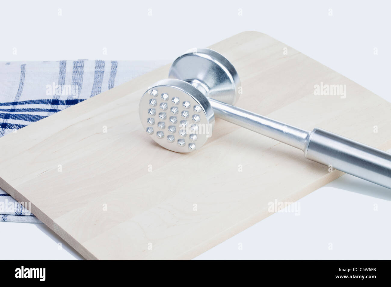 Meat tenderizer, chopping board and dish towel, close-up Stock Photo