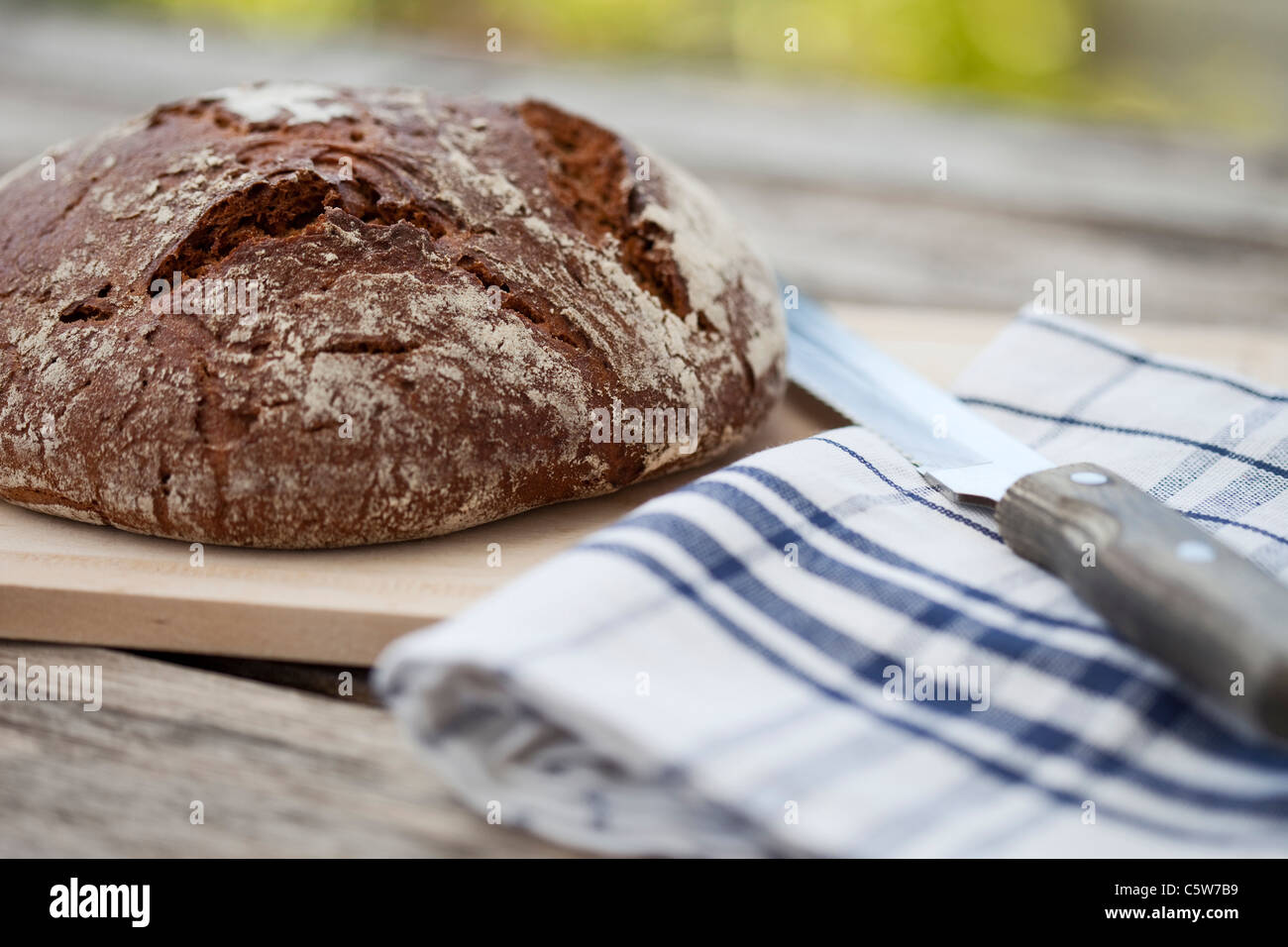 Loaf of farmhouse bread on wooden table Stock Photo