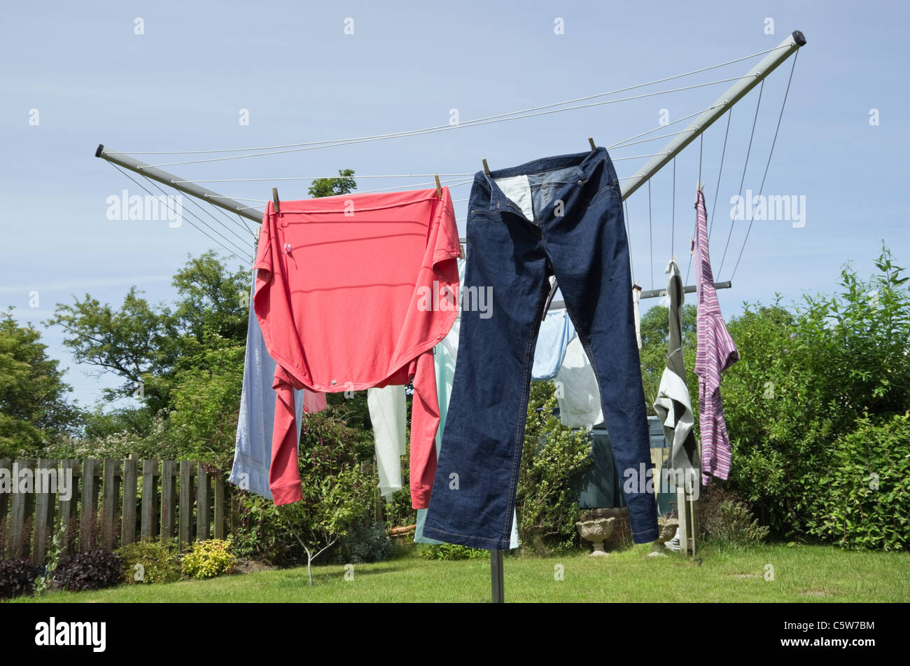 Wet clothes hanging on a rotary washing line to dry outdoors in a Stock