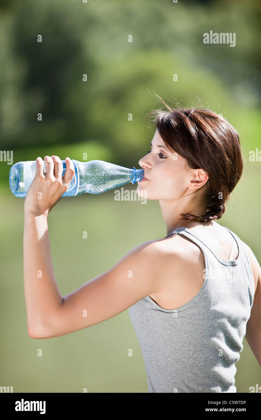 Germany, Bavaria, Young woman drinking water, side view, portrait Stock Photo