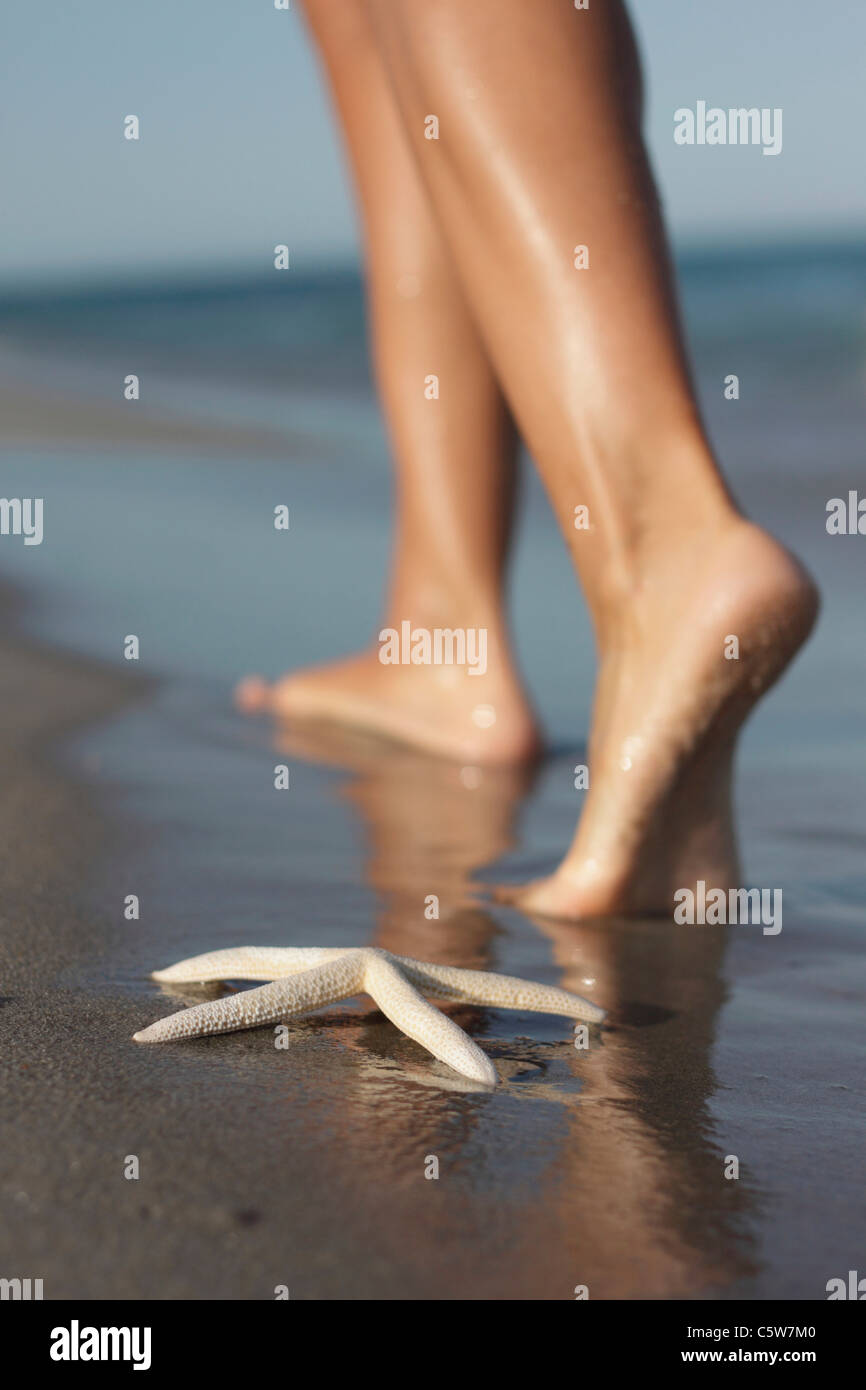 Italy, Sardinia, Woman's feet walking on sandy beach Stock Photo