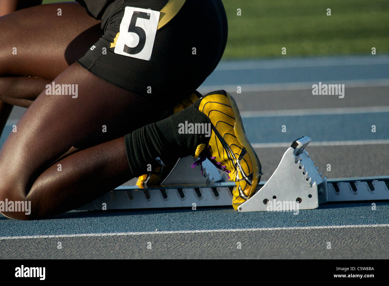 A girl in the starting blocks on a running track Stock Photo