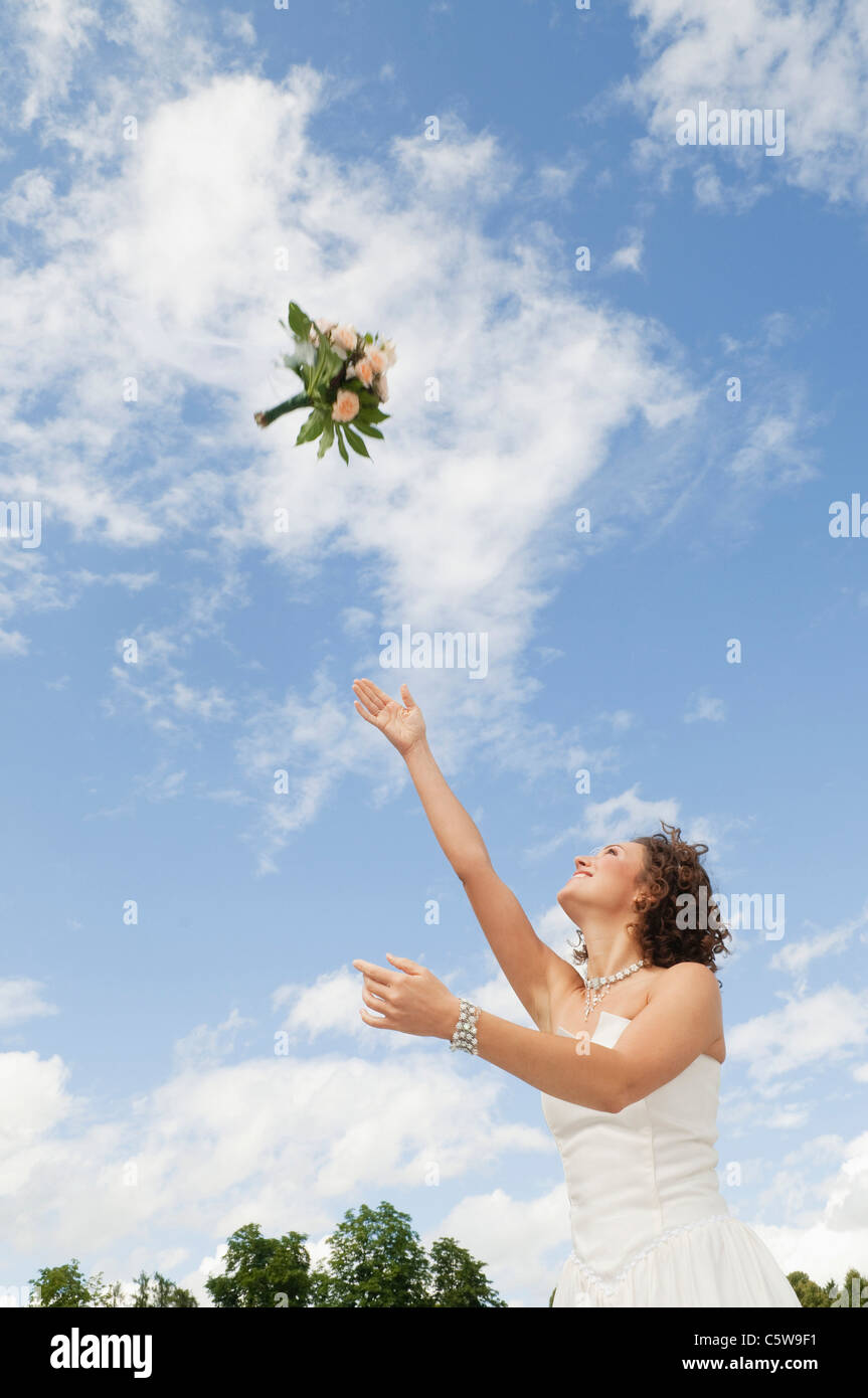 Germany, Bavaria, Young bride throwing a bouquet into the sky Stock Photo Alamy
