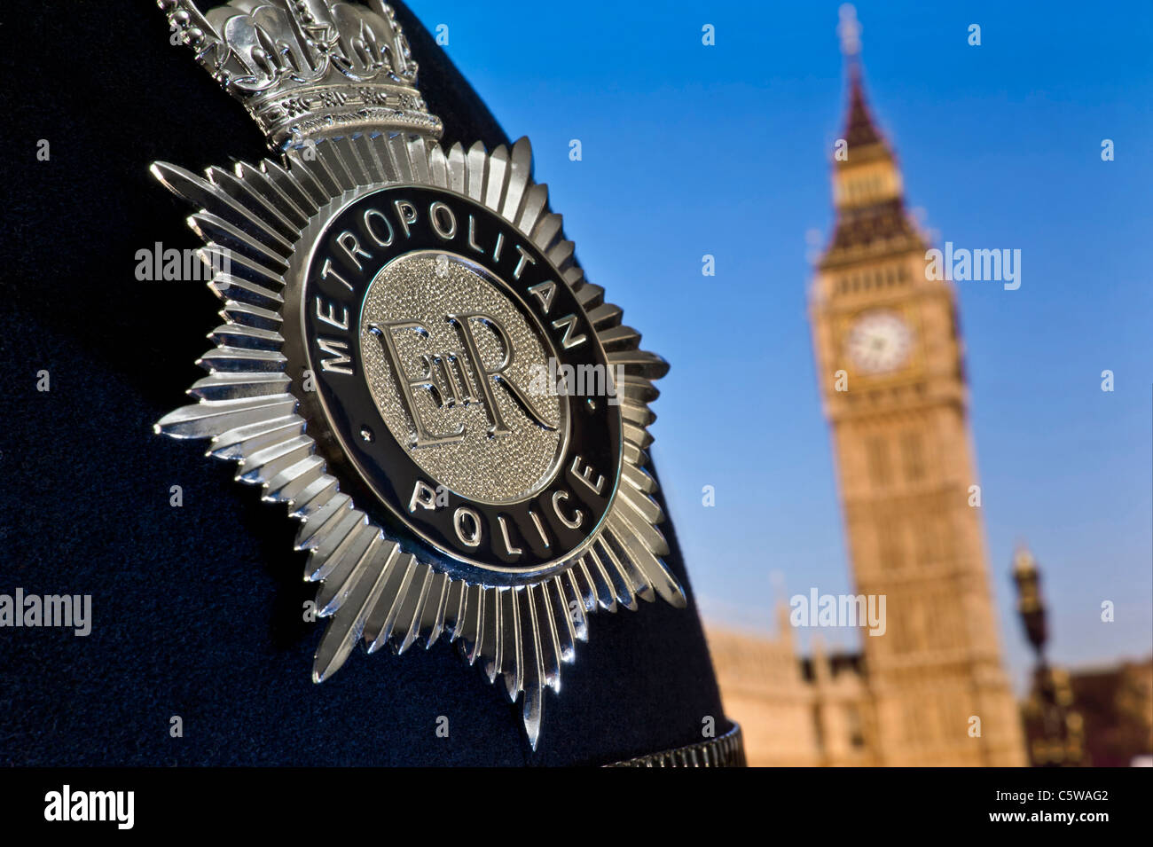 POLICE HELMET LONDON Metropolitan police helmet and badge with Houses of Parliament Big Ben behind Westminster London UK Met.Police Concept Parliament Stock Photo