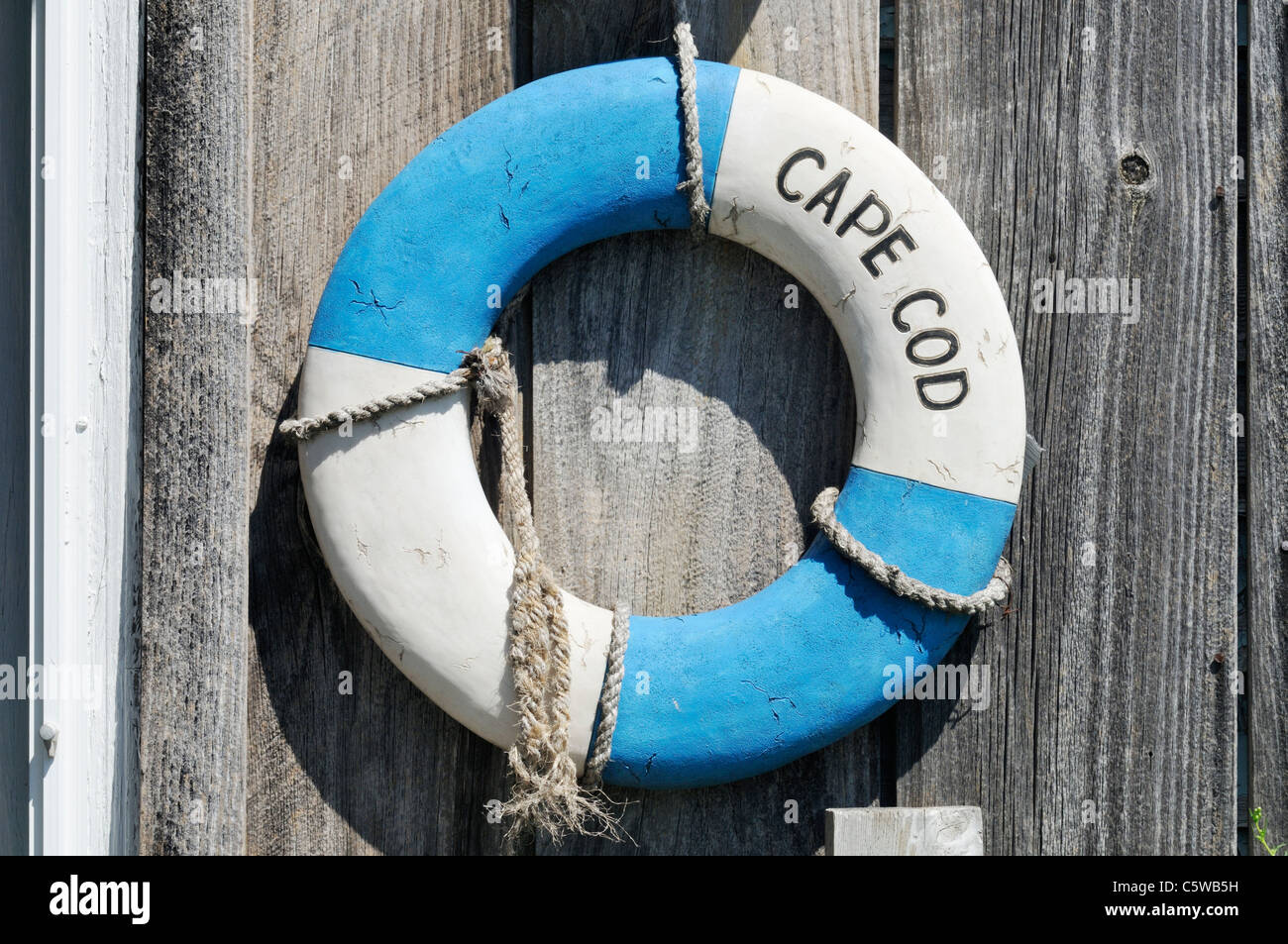 Classic Cape Cod life ring on weathered wood on exterior of building, USA. Stock Photo
