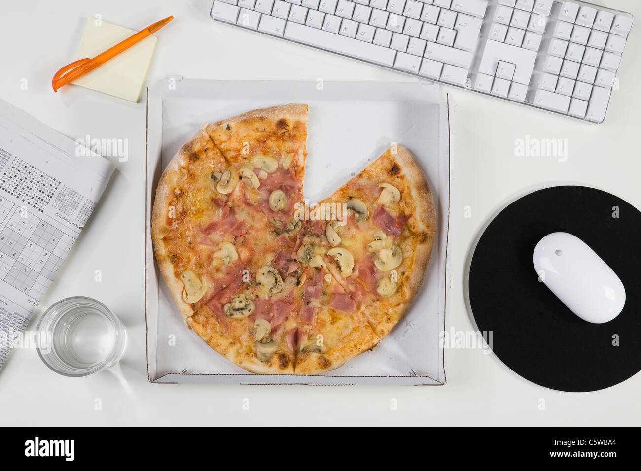 Pizza box on office desk, elevated view Stock Photo