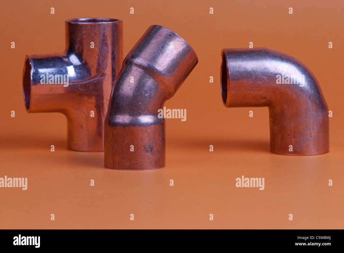 Close up of three metal pipe fittings tee, bend, and corner Stock Photo
