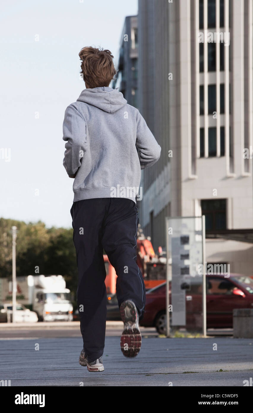 Germany, Berlin, Young man jogging, skyscrapers in background Stock Photo