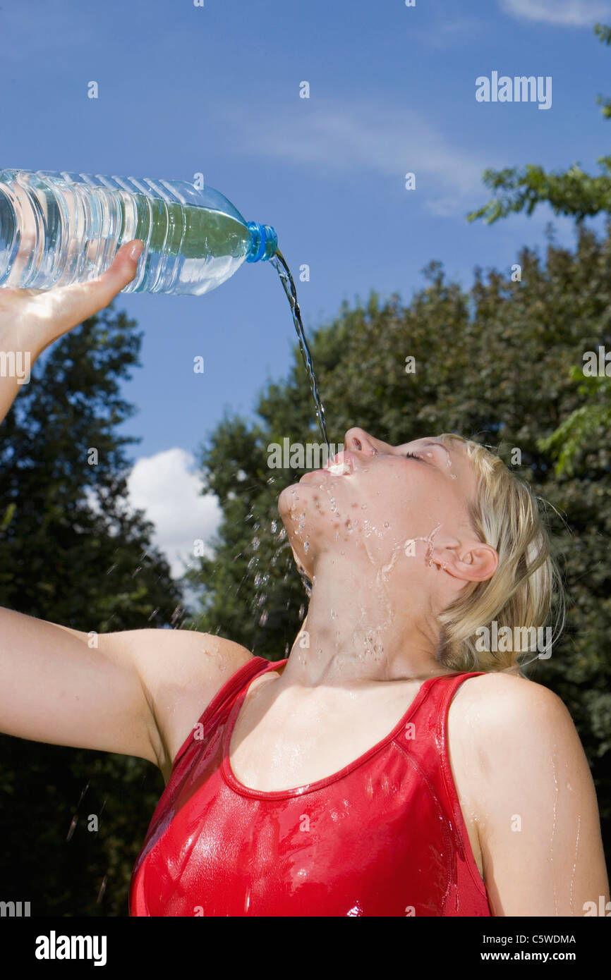 Germany, Berlin, Woman pouring water over face, portrait Stock Photo