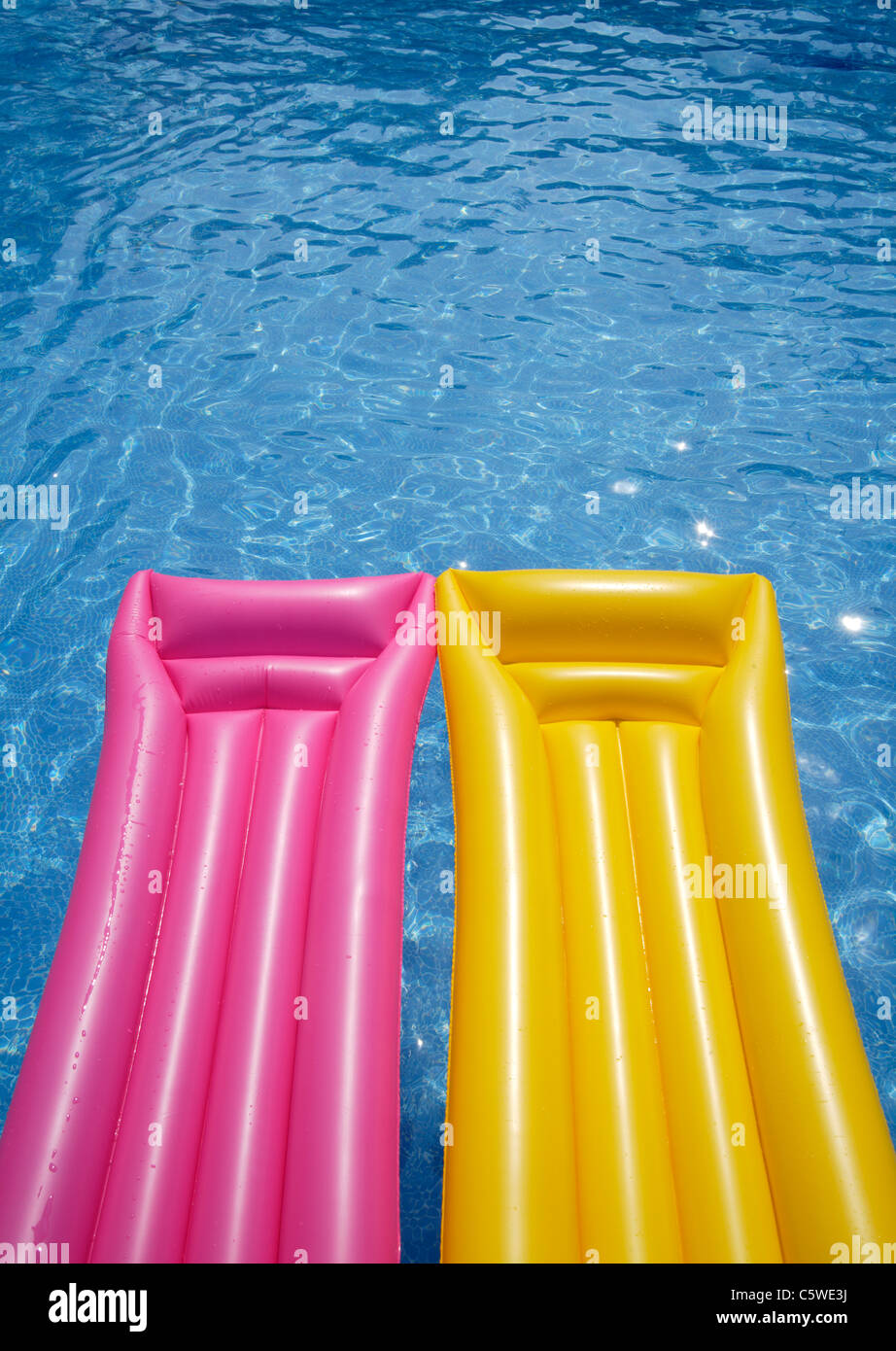 Two airbeds floating in pool, elevated view Stock Photo