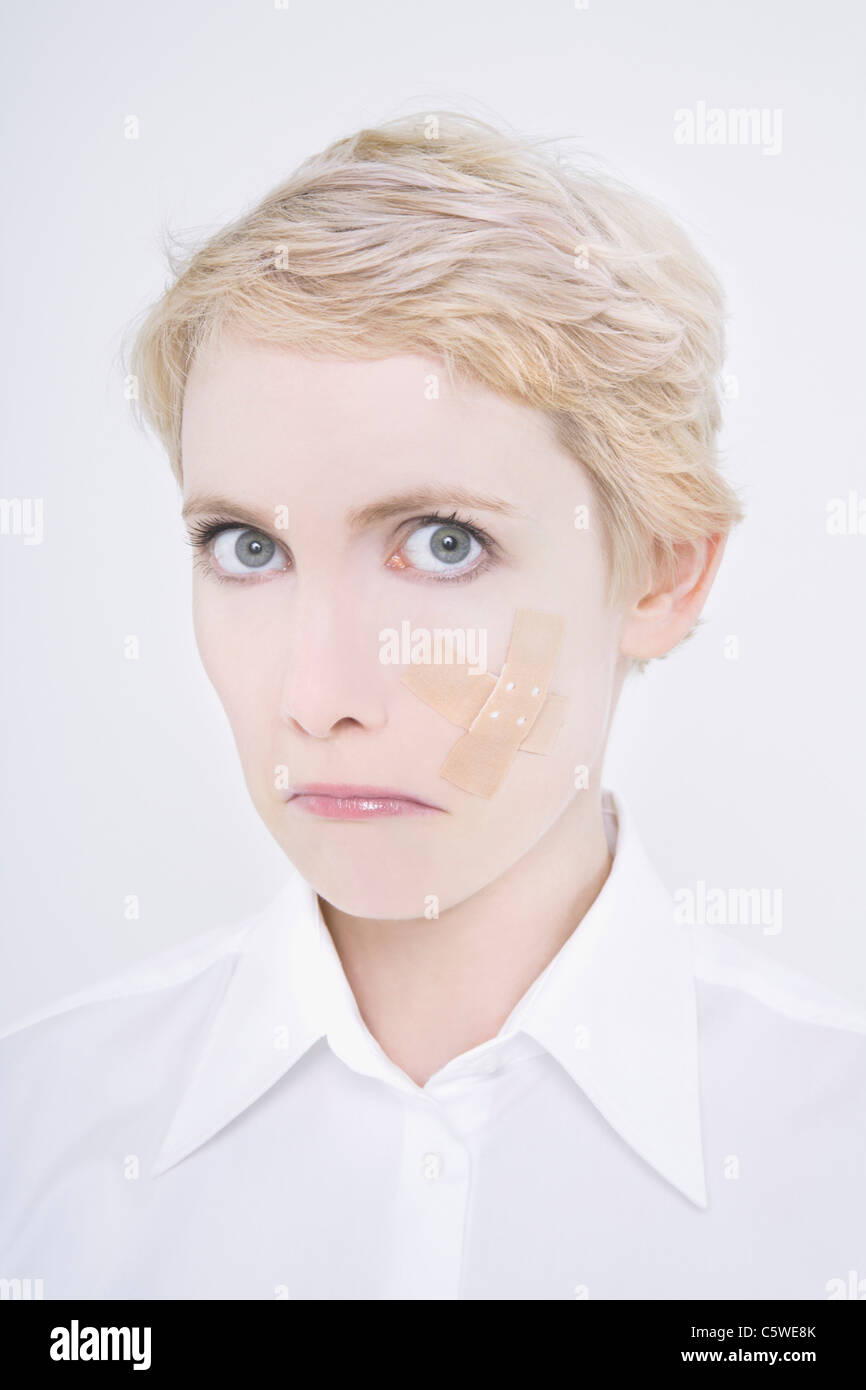 Woman with band-aid on cheek Stock Photo