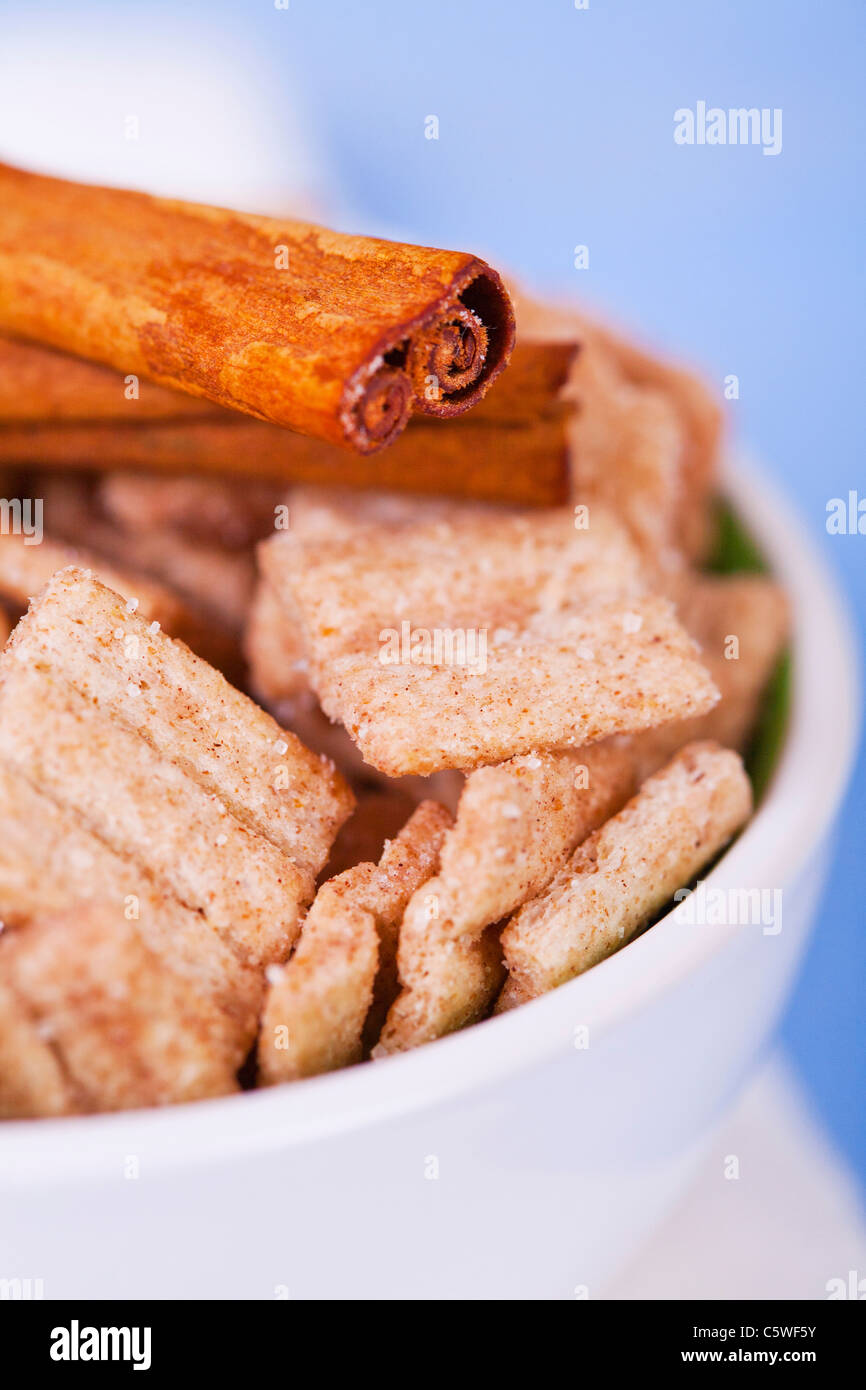 Close up of cinnamon cereal chips in bowl with cinnamon stick on top of it Stock Photo