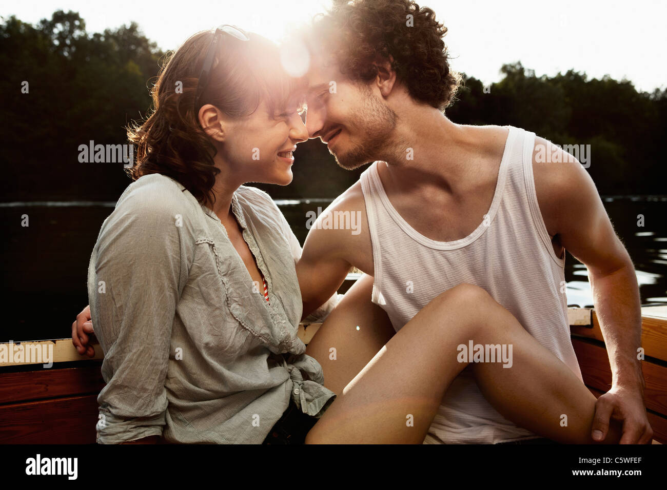 Germany, Berlin, Young couple on motor boat, head to head, portrait Stock Photo