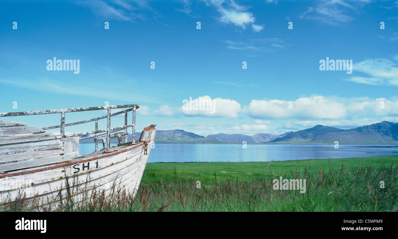 Iceland, Snaefelnes, View of old boat at fjord shore with mountains Stock Photo