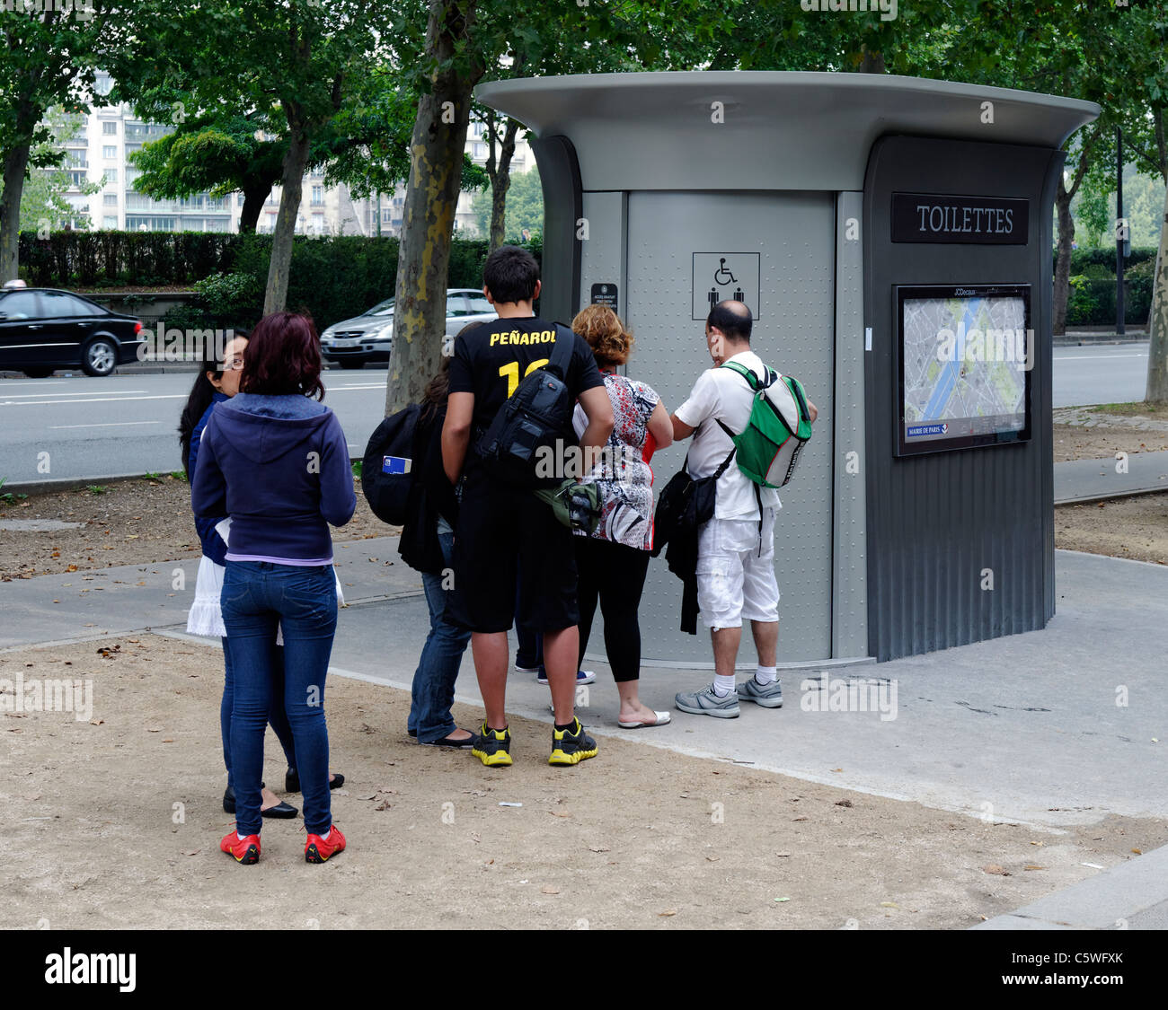Tourists queue to use the public toilet by the Eiffel Tower in Paris