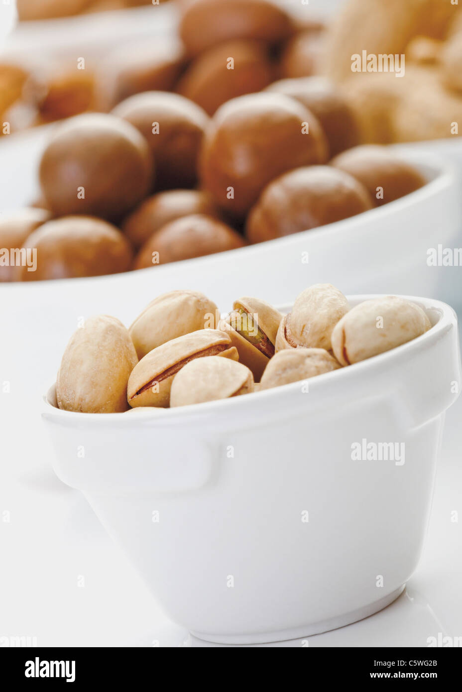 Pistachios and other nuts in bowls Stock Photo