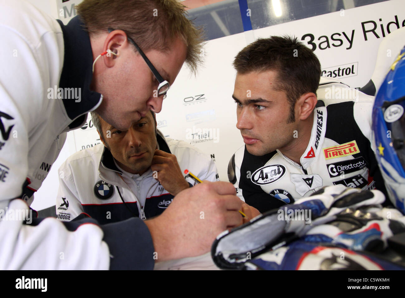 Leon Haslam discusses lap times with pit crew before second practice at Silverstone Stock Photo