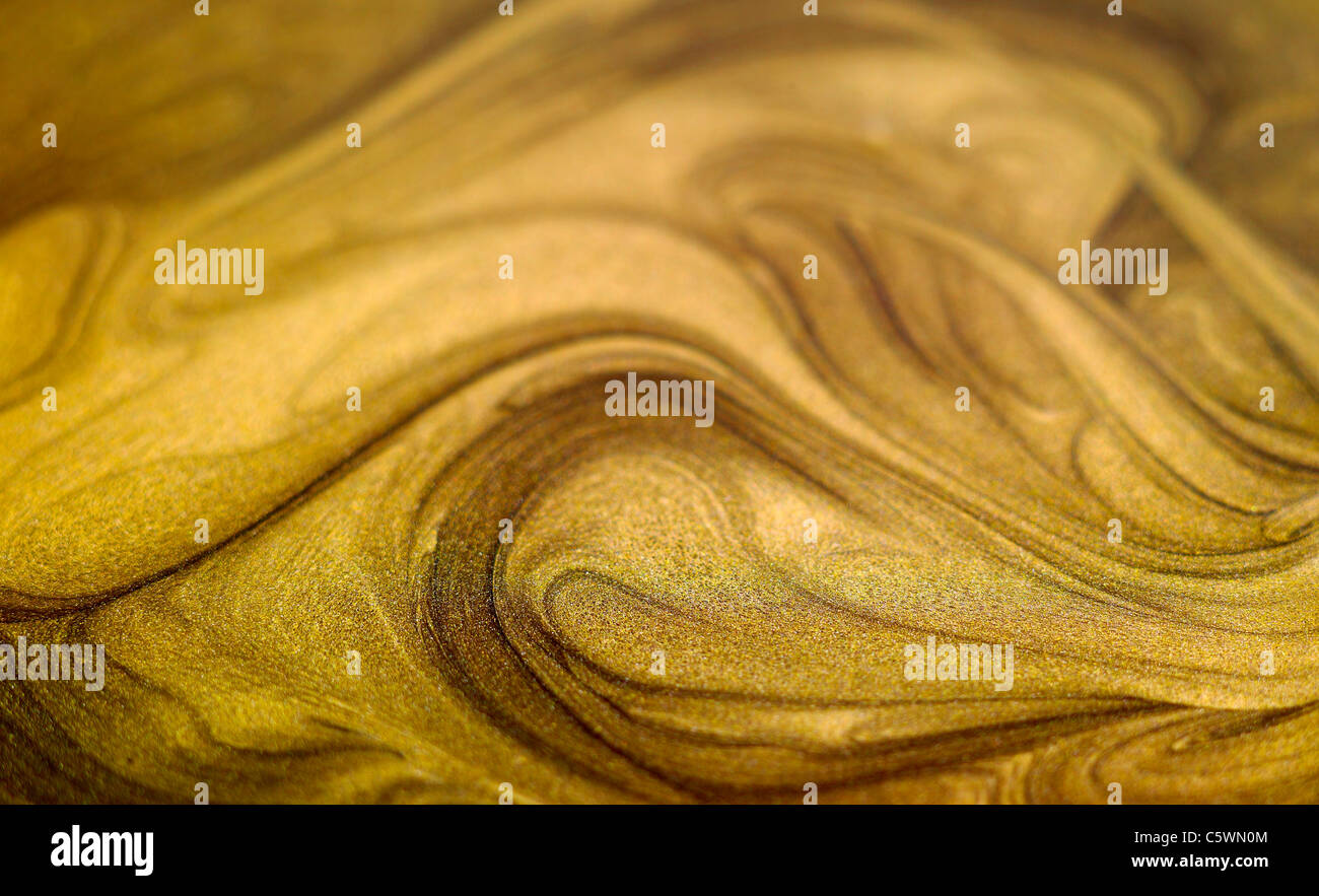 Gold swirling paint background Stock Photo