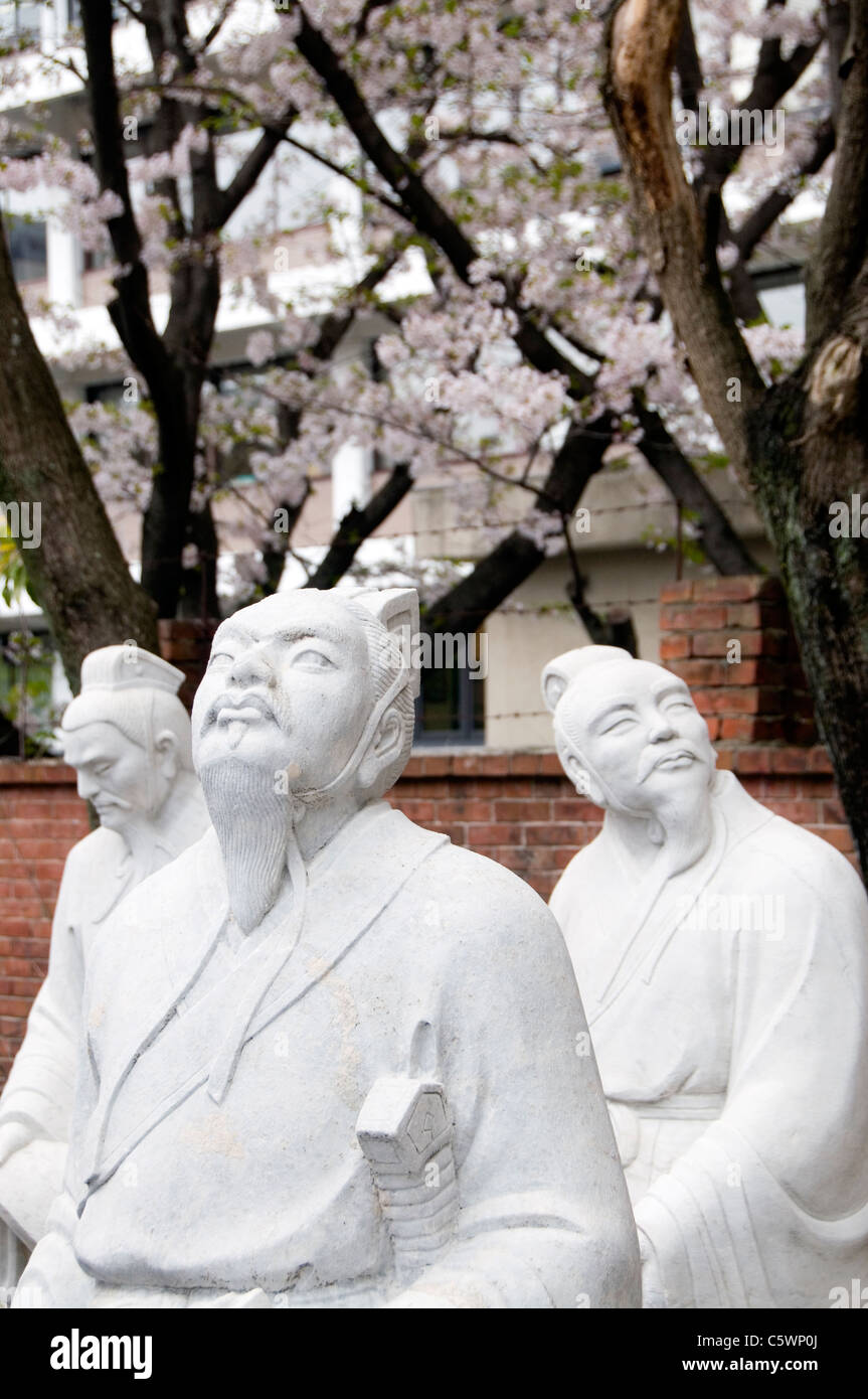 Statues of Confucian scholars admiring the cherry blossoms at the Confucian Shrine in Nagasaki, Japan Stock Photo