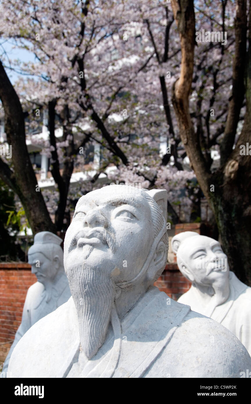 Statues of Confucian scholars admiring cherry blossoms in the Confucion Shrine in Nagasaki, Japan. Stock Photo