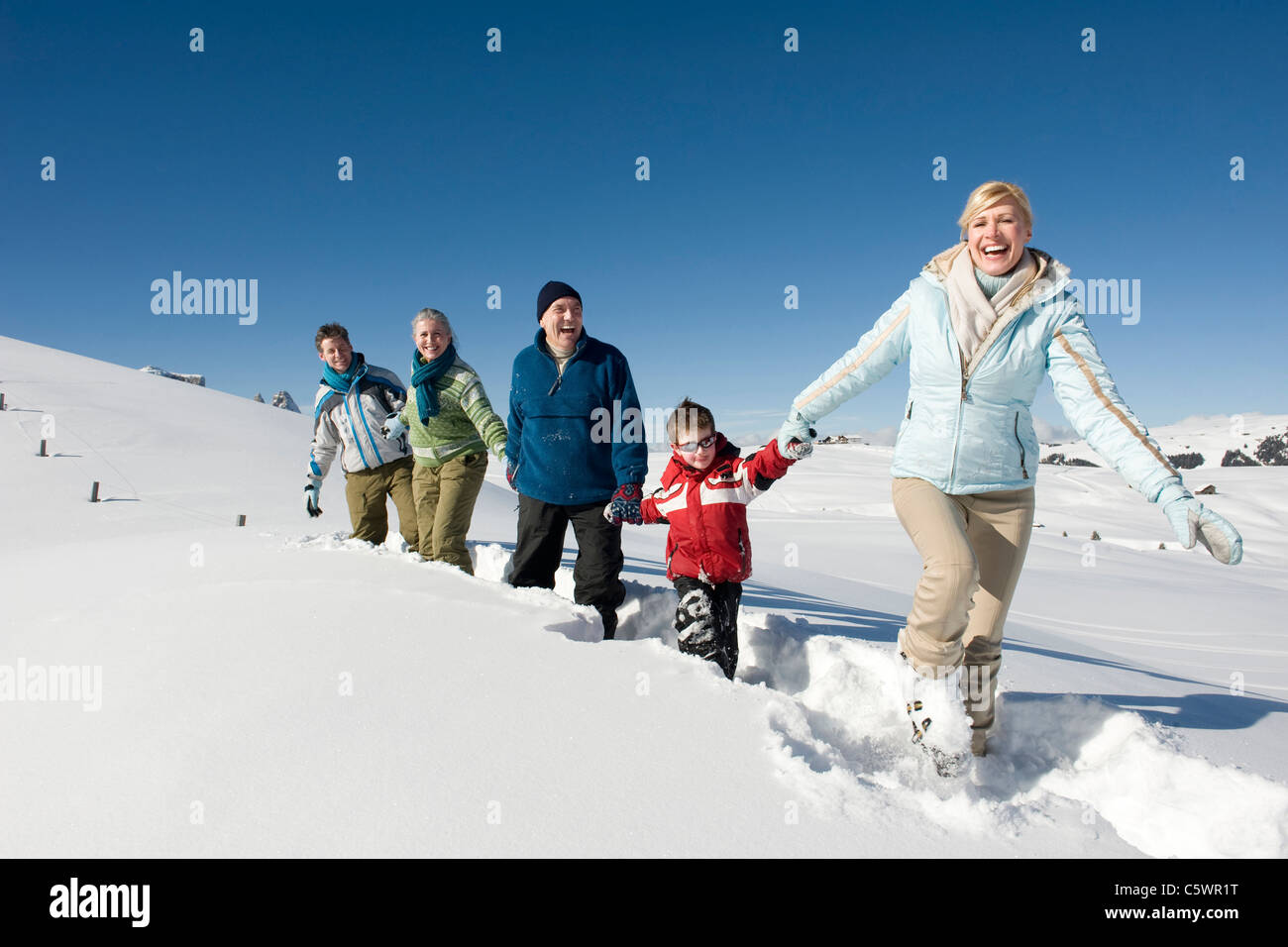 Italy, South Tyrol, Seiseralm, Family walking in snow Stock Photo