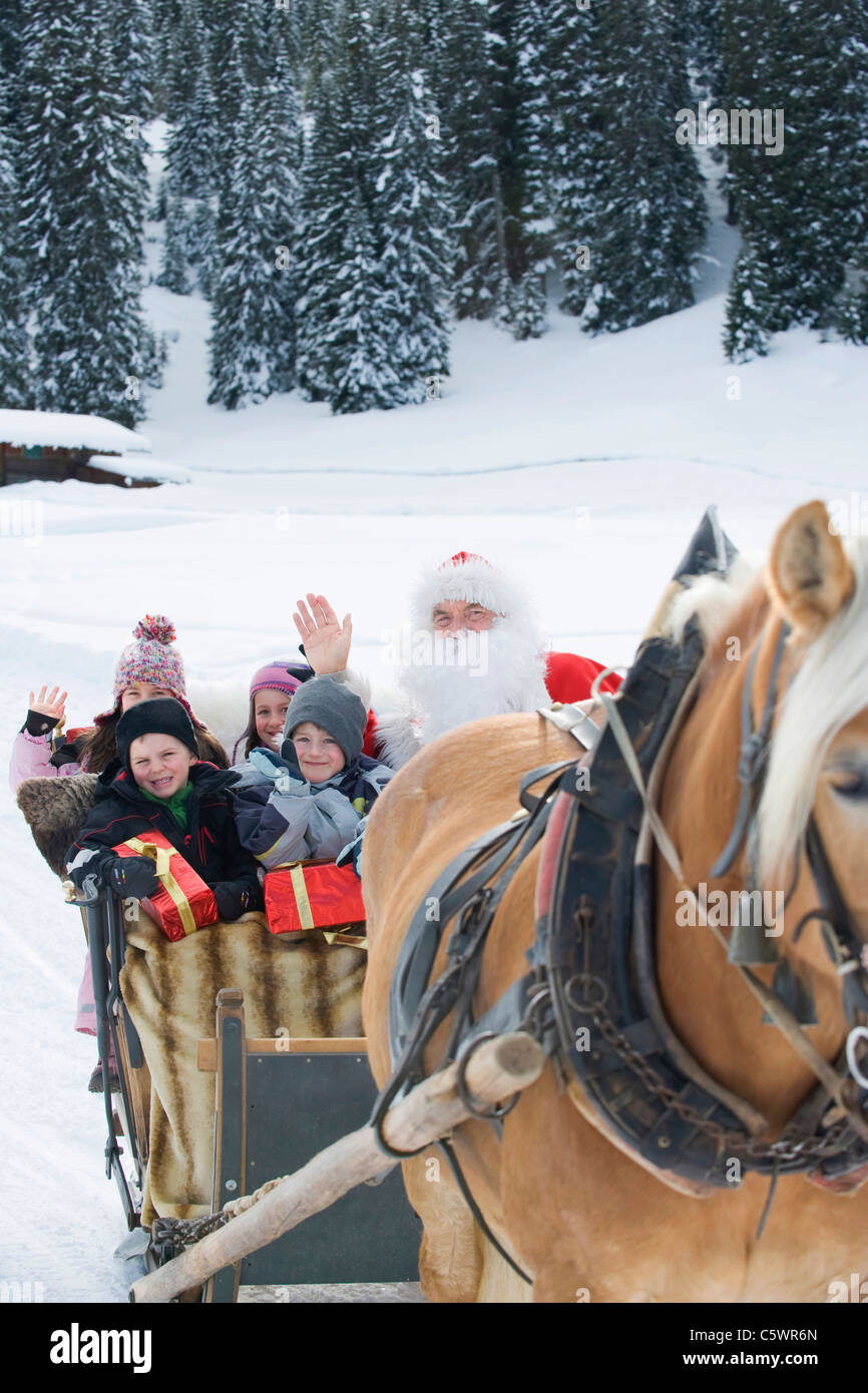 Italy, South Tyrol, Seiseralm, Santa Claus and children taking a sleigh ride Stock Photo