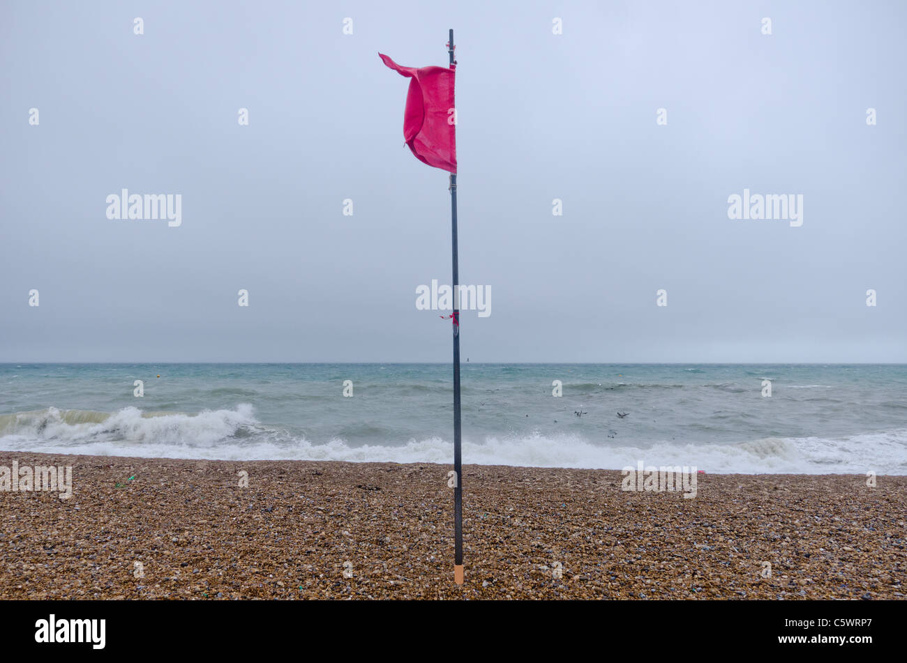 A man braves the stormy weather at Saltdean, East East Sussex, promenade, as waves hit the breakwater. Stock Photo