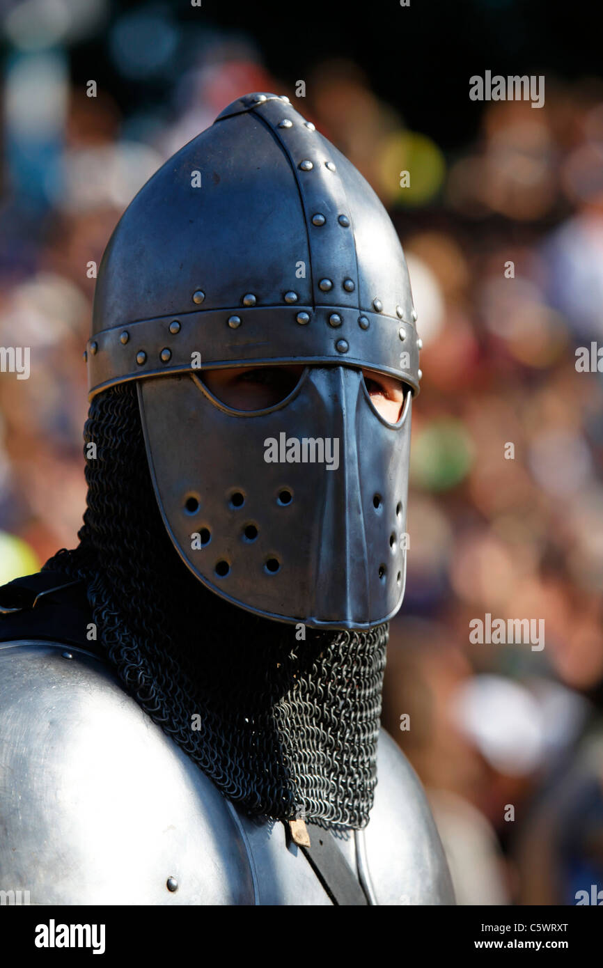 A man wears a metal helmet and chain mail, representing the type of
