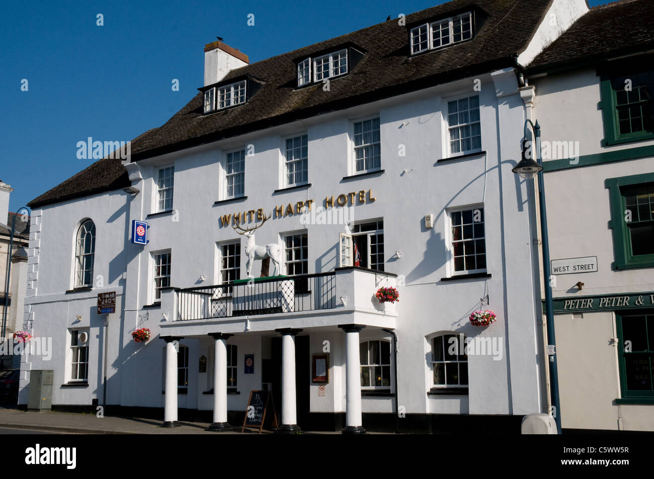 The White Hart Hotel is situated in the center of Okehampton and features a model of a white stag above the main entrance. Stock Photo