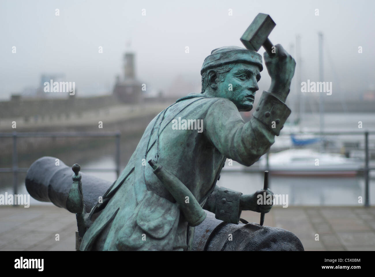Sculpture of man spiking the touchhole of a cannon, on the quayside at Whitehaven, Cumbria, England UK Stock Photo