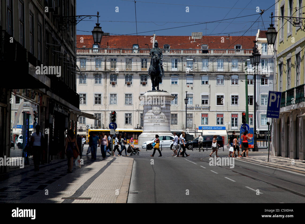 A glimpse of Rossio square, the Dom Pedro IV Statue and some crowd and busses Stock Photo