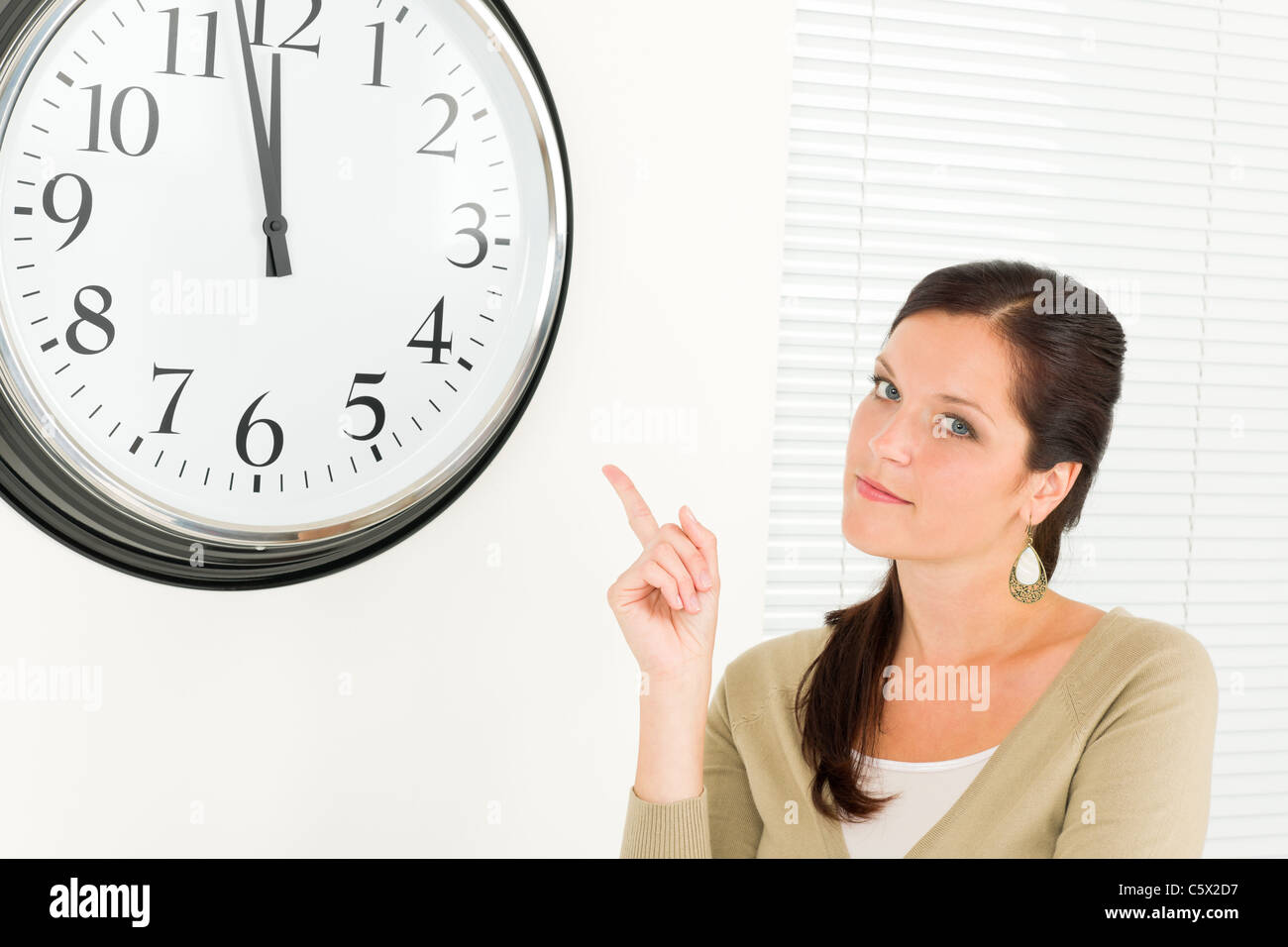 Punctual businesswoman young attractive pointing at clock portrait Stock Photo