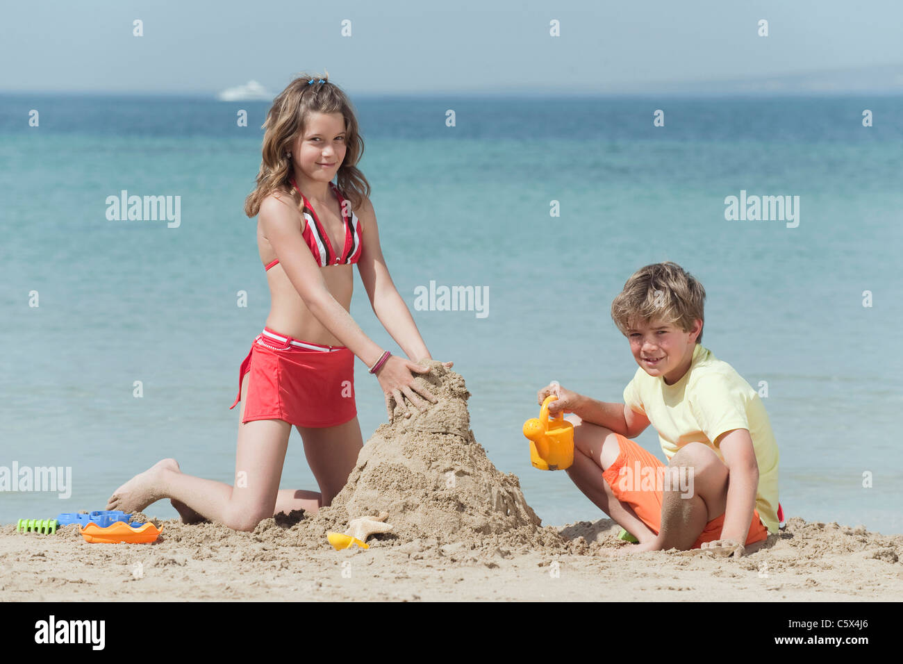 Spain, Mallorca, Children building sandcastle on beach Stock Photo