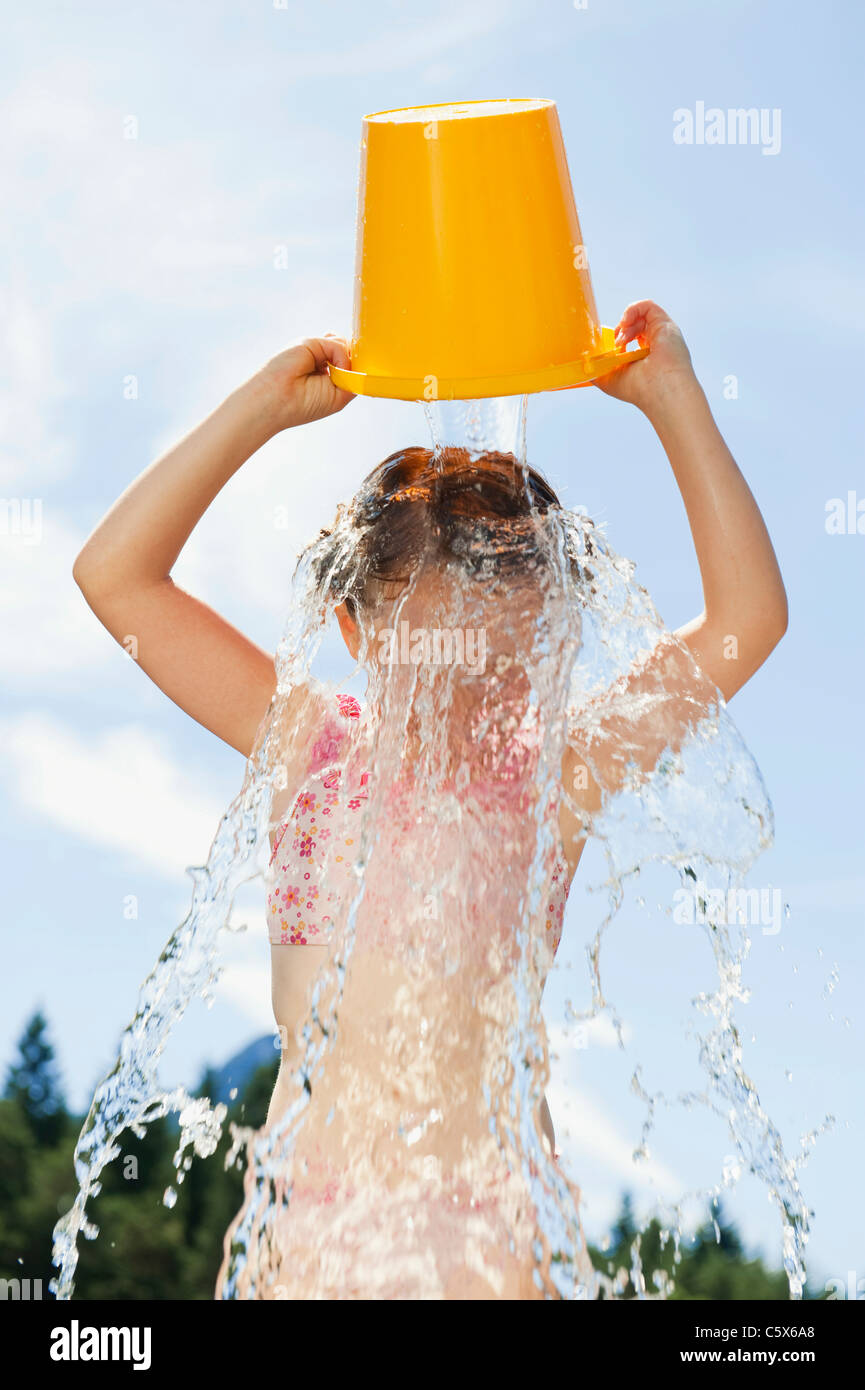 Italy, South Tyrol, Girl (6-7) pouring a bucket of water over her head  Stock Photo - Alamy
