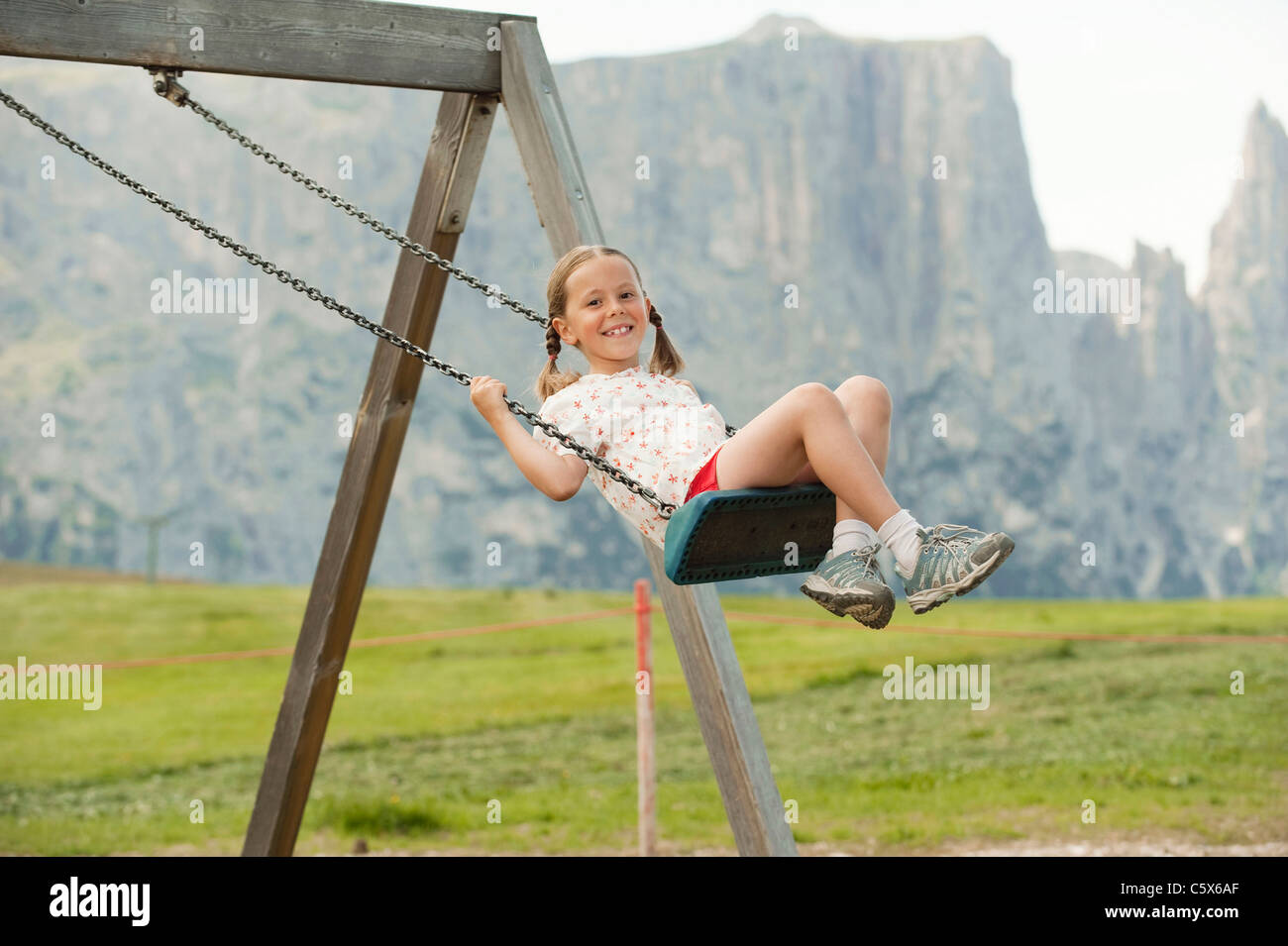 Boy and girl sharing swing on summer day in Sweden Stock Photo - Alamy