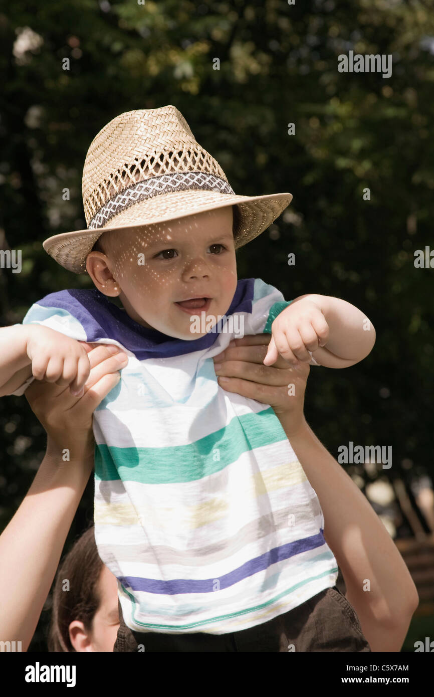 Germany, Berlin, Person lifting boy (2-3), laughing, portrait, close-up Stock Photo