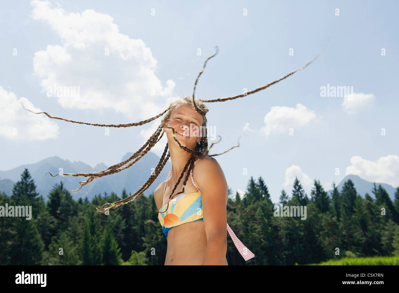 Italy, South Tyrol, Girl (13-14) with dreadlocks, smiling, portrait Stock Photo