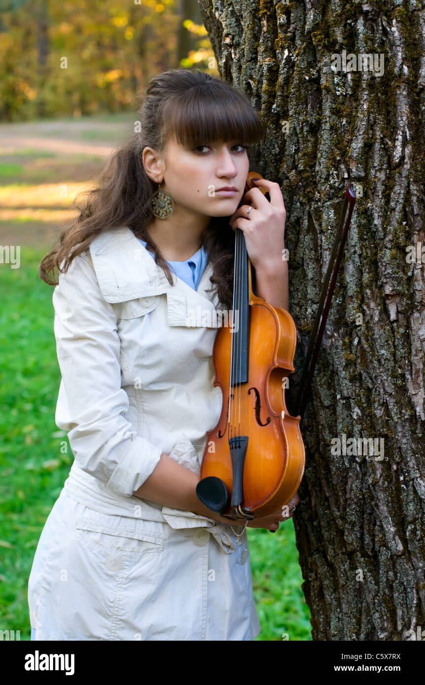 The young woman with a violin listens to music of autumn Stock Photo ...