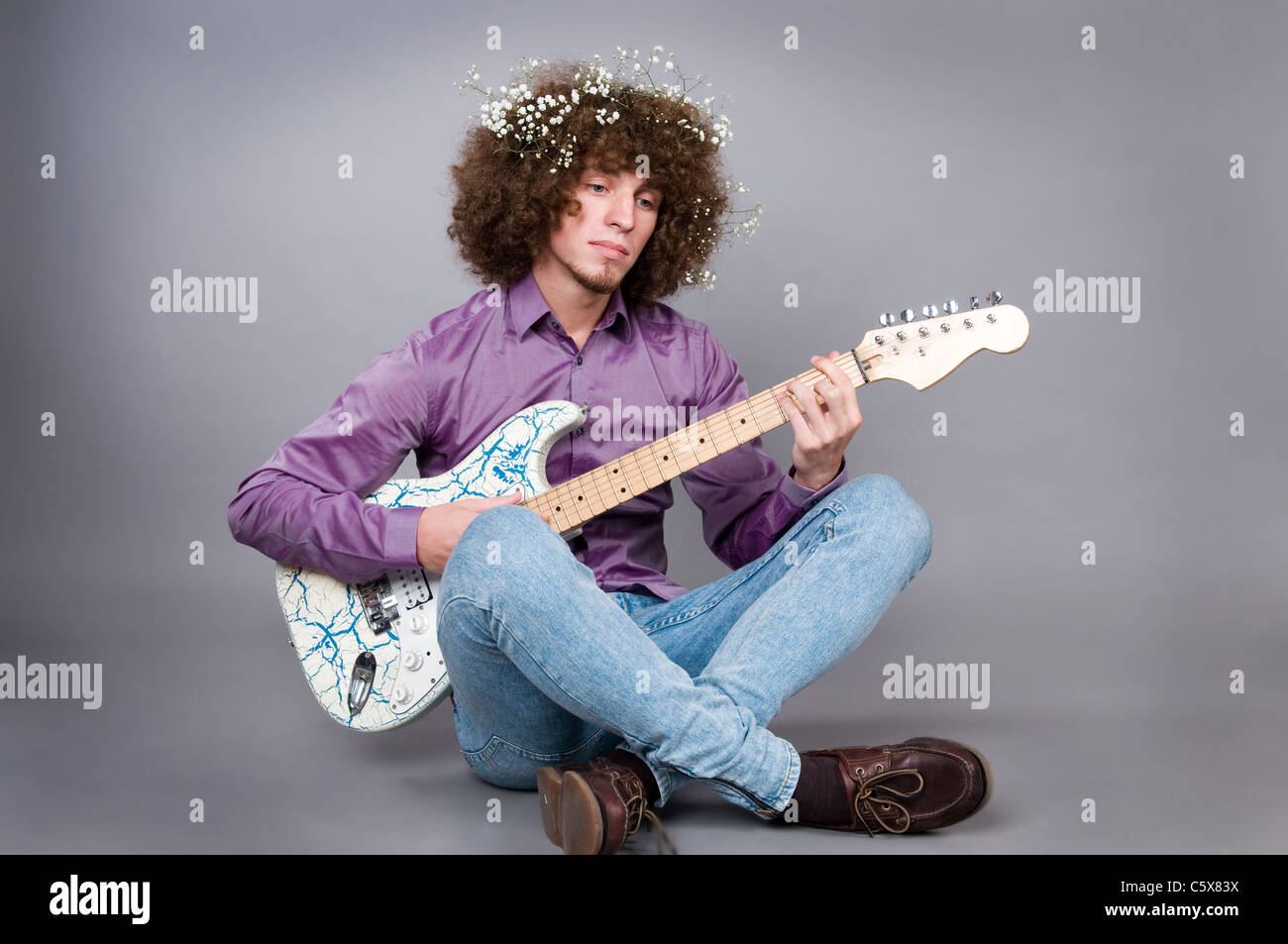 The young guy with curly hair and a guitar Stock Photo - Alamy