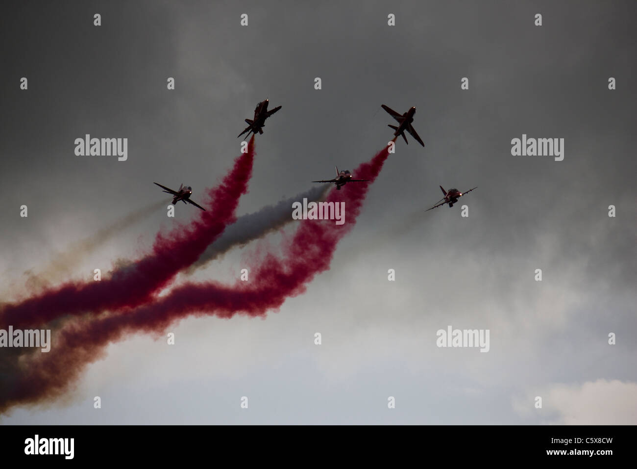 The Red Arrows RAF aerobatic display team flying through stormy clouds Stock Photo