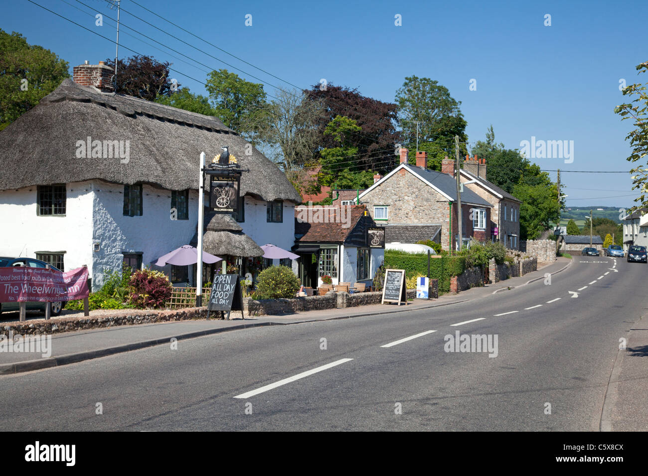 Main road with the Wheelwright pub in the foreground, Colyford, Devon Stock Photo