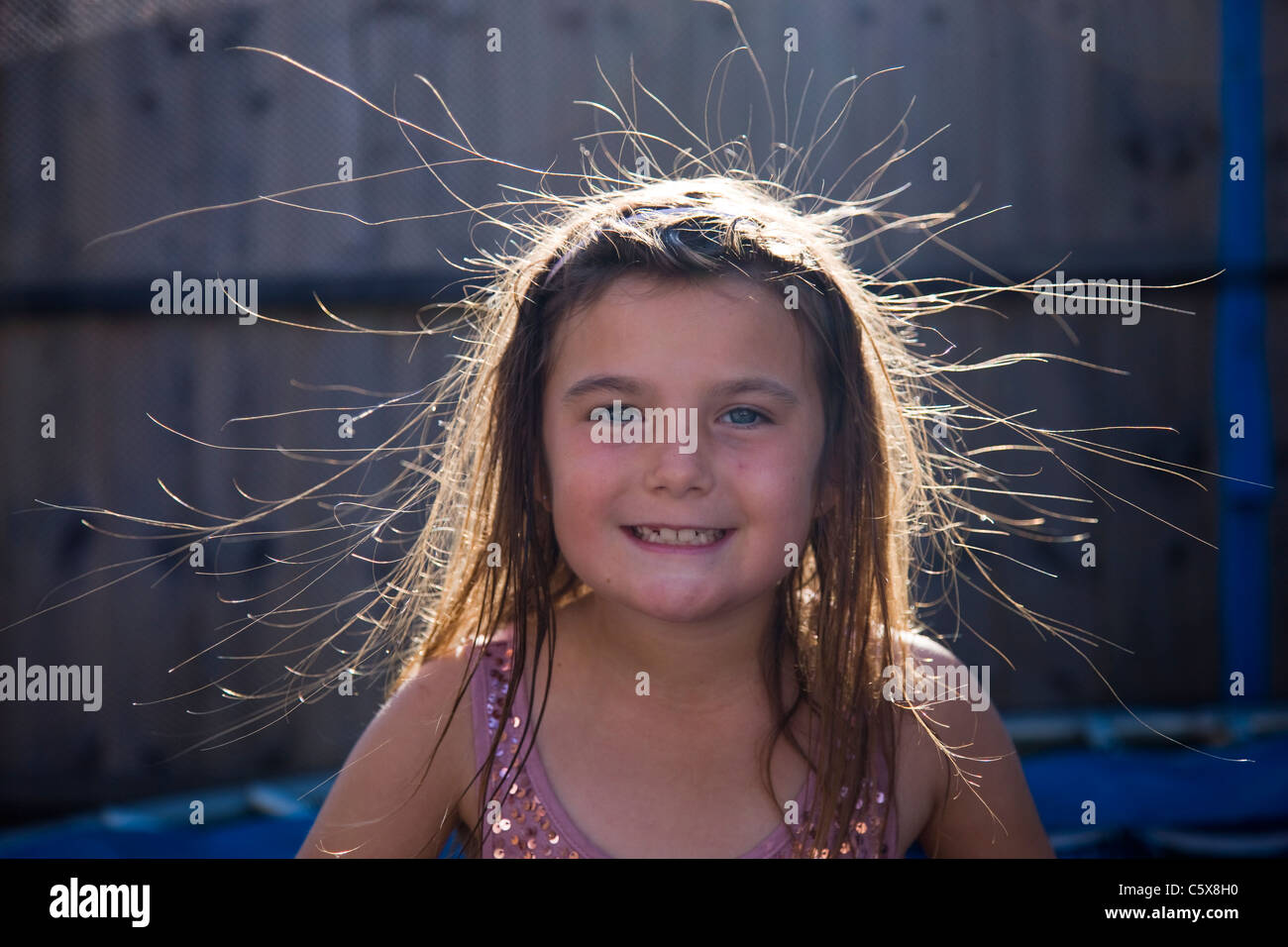 Little girl whose hair has been made to stand up on end by static electricity from a trampoline Stock Photo