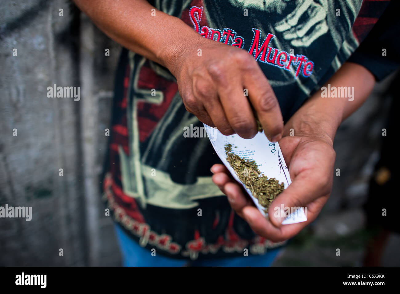 A Mexican follower of Santa Muerte (Holy Death) smokes a marijuana  cigarette during a pilgrimage in Tepito, Mexico City, Mexico Stock Photo -  Alamy