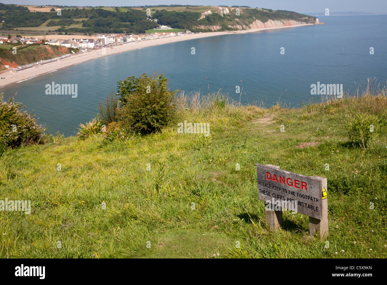 Warning sign for unstable cliffs on clifftop, Seaton, Devon Stock Photo