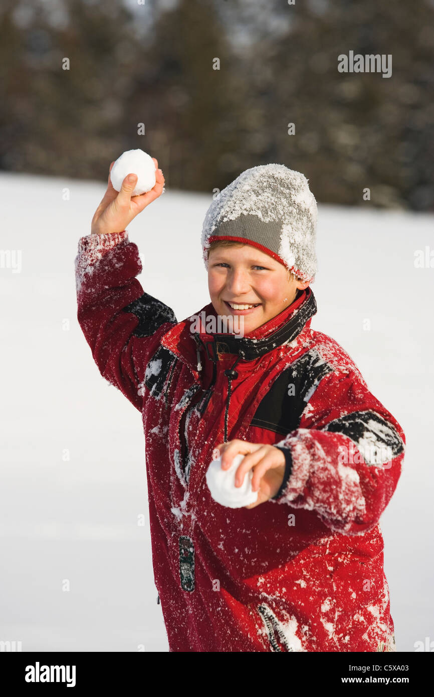 Austria, Steiermark, Boy (12-13) holding snowball, smiling, portrait Stock Photo
