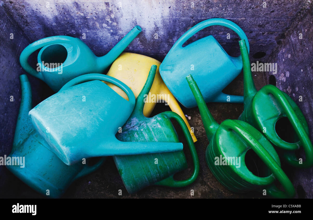 Watering cans in a trough, elevated view Stock Photo