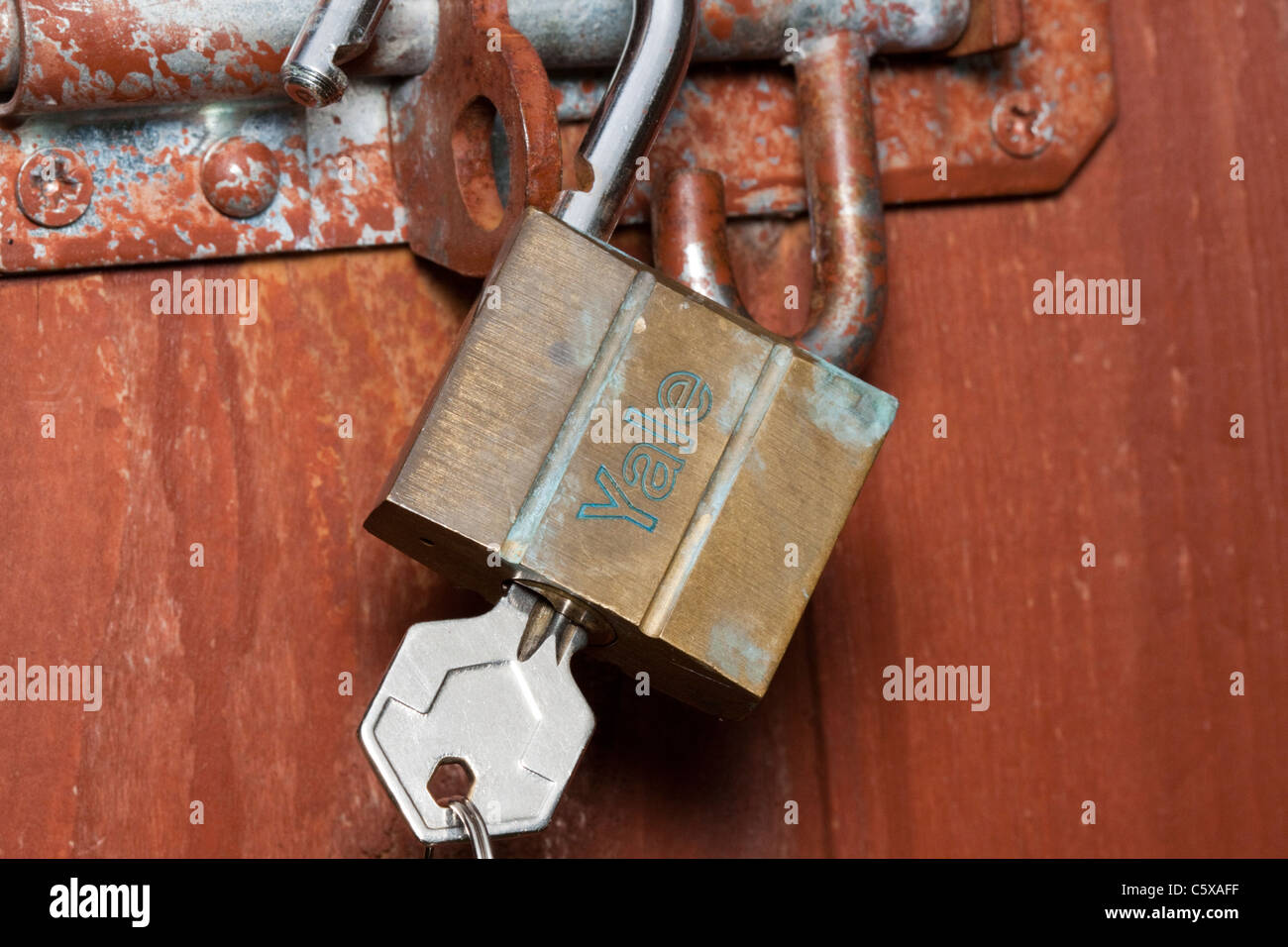 Unlocked padlock and key on a shed door illustrating garden security Stock Photo
