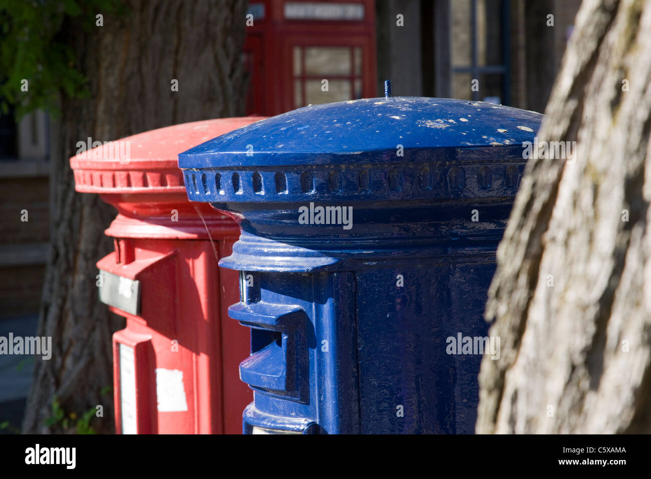 Blue and red pillar post boxes side by side Stock Photo Alamy
