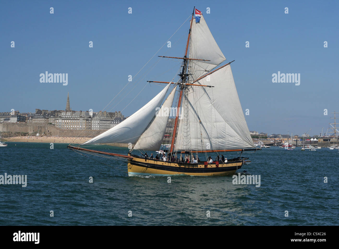 The corsair cutter 'the Fox' sails in front of St Malo (Brittany, France). Stock Photo
