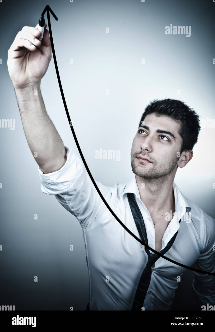 Young business man drawing a rising arrow on a glass board Stock Photo ...